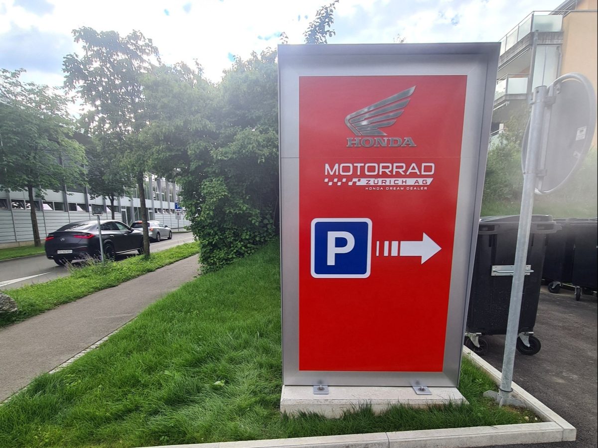 Wegweiser zu den Gratis-Parkplätzen bei Honda Motorrad Zürich